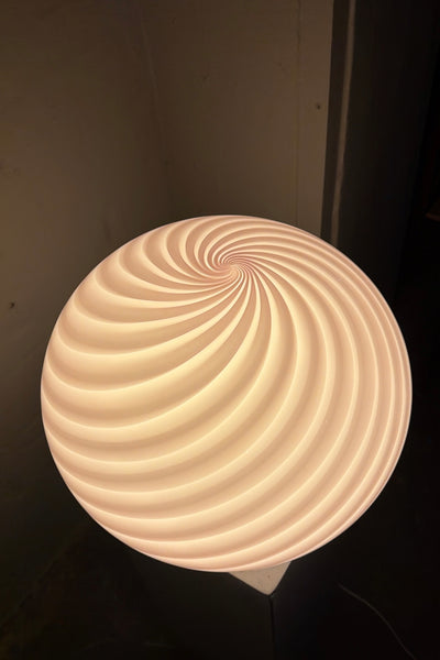 Murano gulvlampe i bubble gum farve med swirl mønster set ovenfra, fremhæver den unikke form og lysrefleksioner