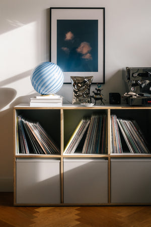 Murano table lamp with blue swirl pattern, placed on a dresser with vinyl records and artwork in the background