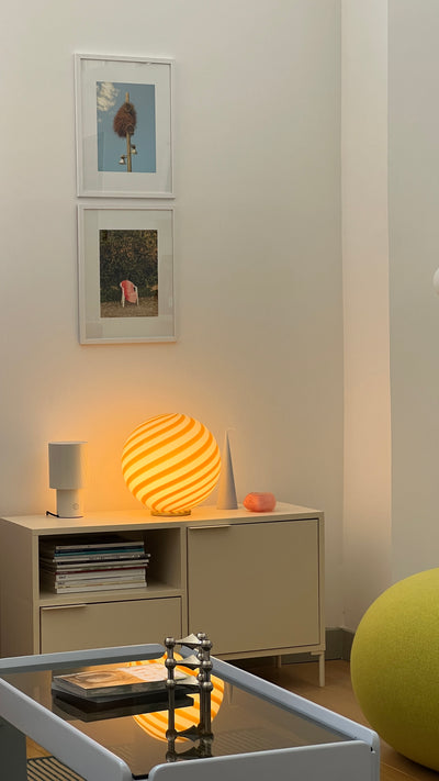 Murano table lamp in yellow/white swirl pattern sits on a dresser in a bright room