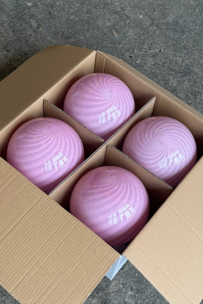 Murano pendant in bubble gum color with swirl pattern, shown in a box with four lamps