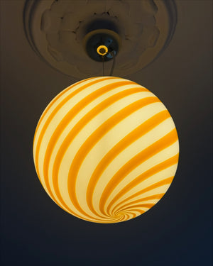 Murano pendant with yellow/white swirl pattern, side view highlighting the round shape and striking colors
