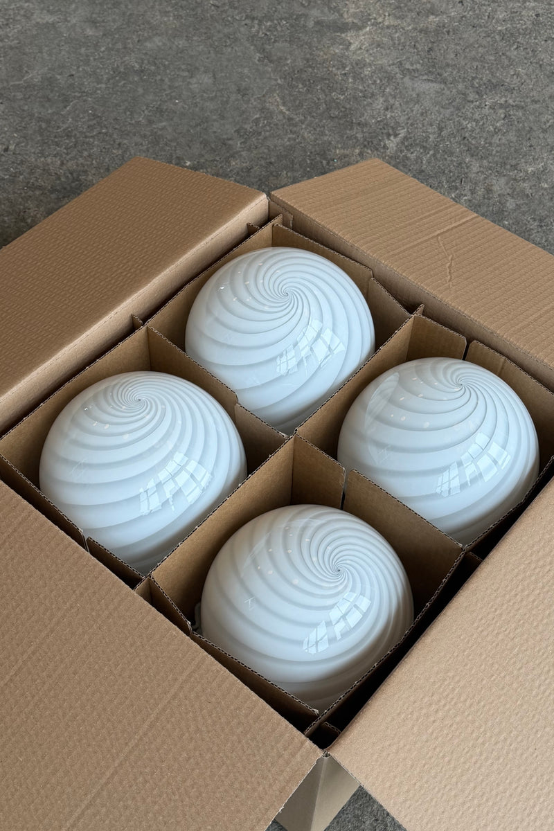 Murano candy bordlampe i hvid swirl mønster, set fra oven i en kasse med fire lamper