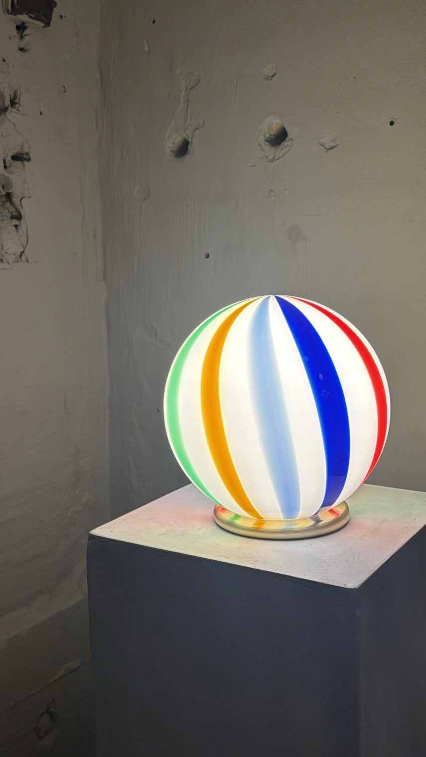 Murano lampe de table bouée de plage en verre soufflé D:20 cm sur un socle montrant un motif tourbillonnant aux couleurs rouge, bleu, jaune et vert