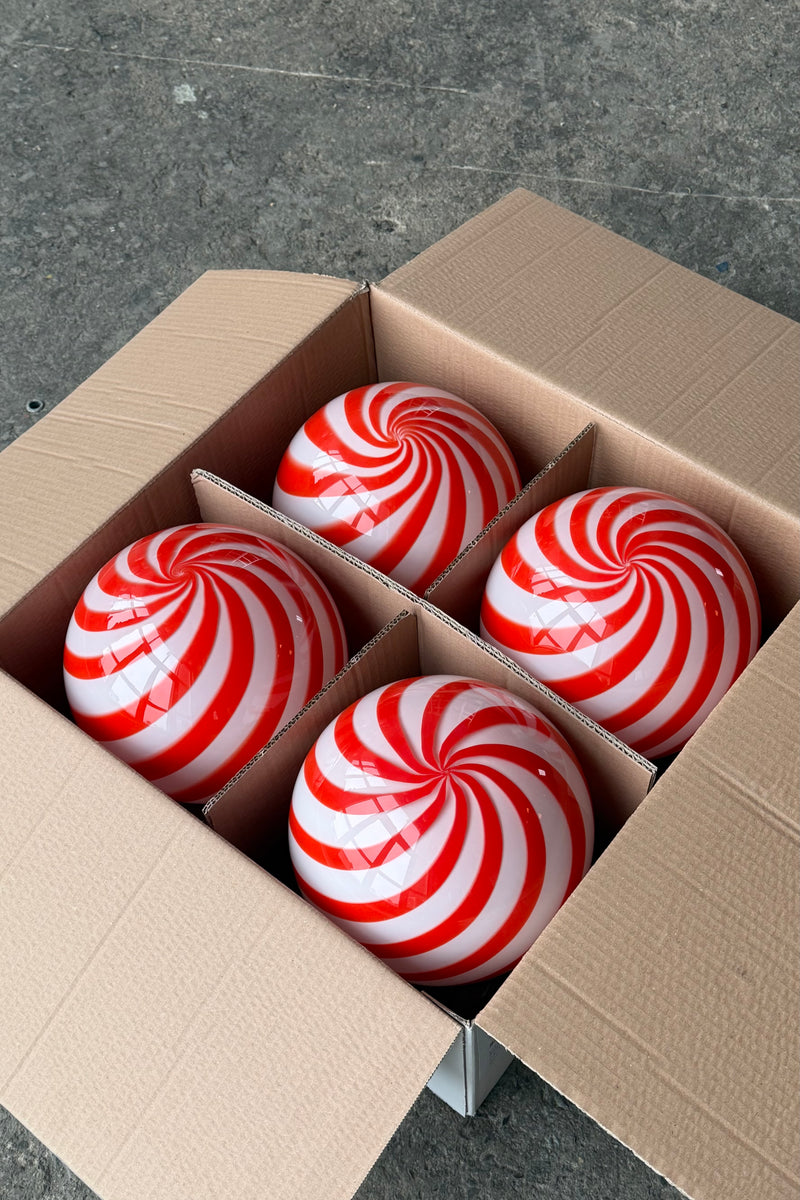 Murano pendel i rød/hvid swirl mønster set fra oven i en papkasse, viser de karakteristiske farver og form