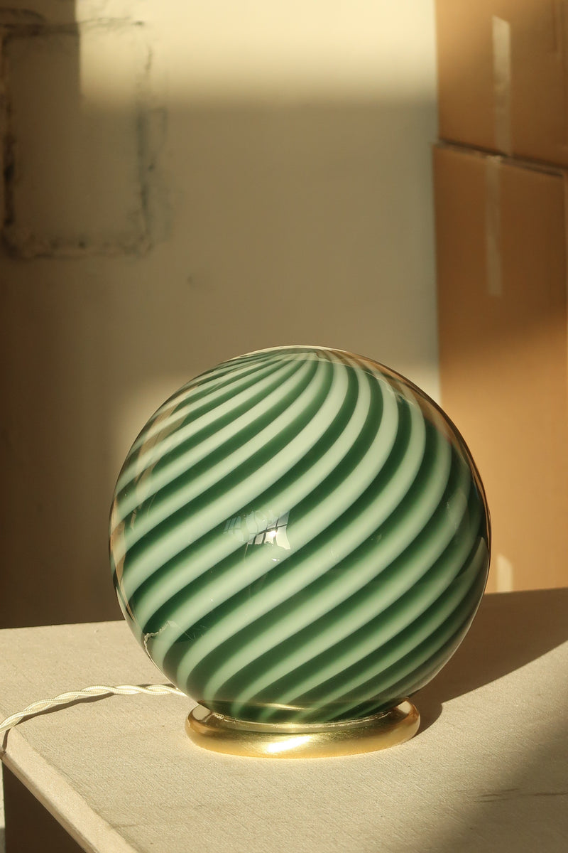 bordlampe i petroleum grøn med swirl mønster, rund form og gylden fod, set i blødt lys