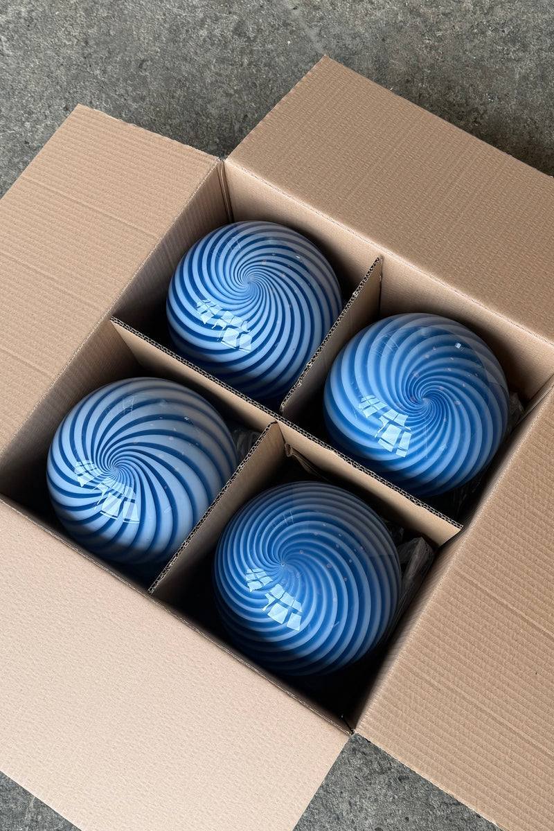 Murano pendel med blå swirl mønster set oppefra i kasse, forklarer det unikke design