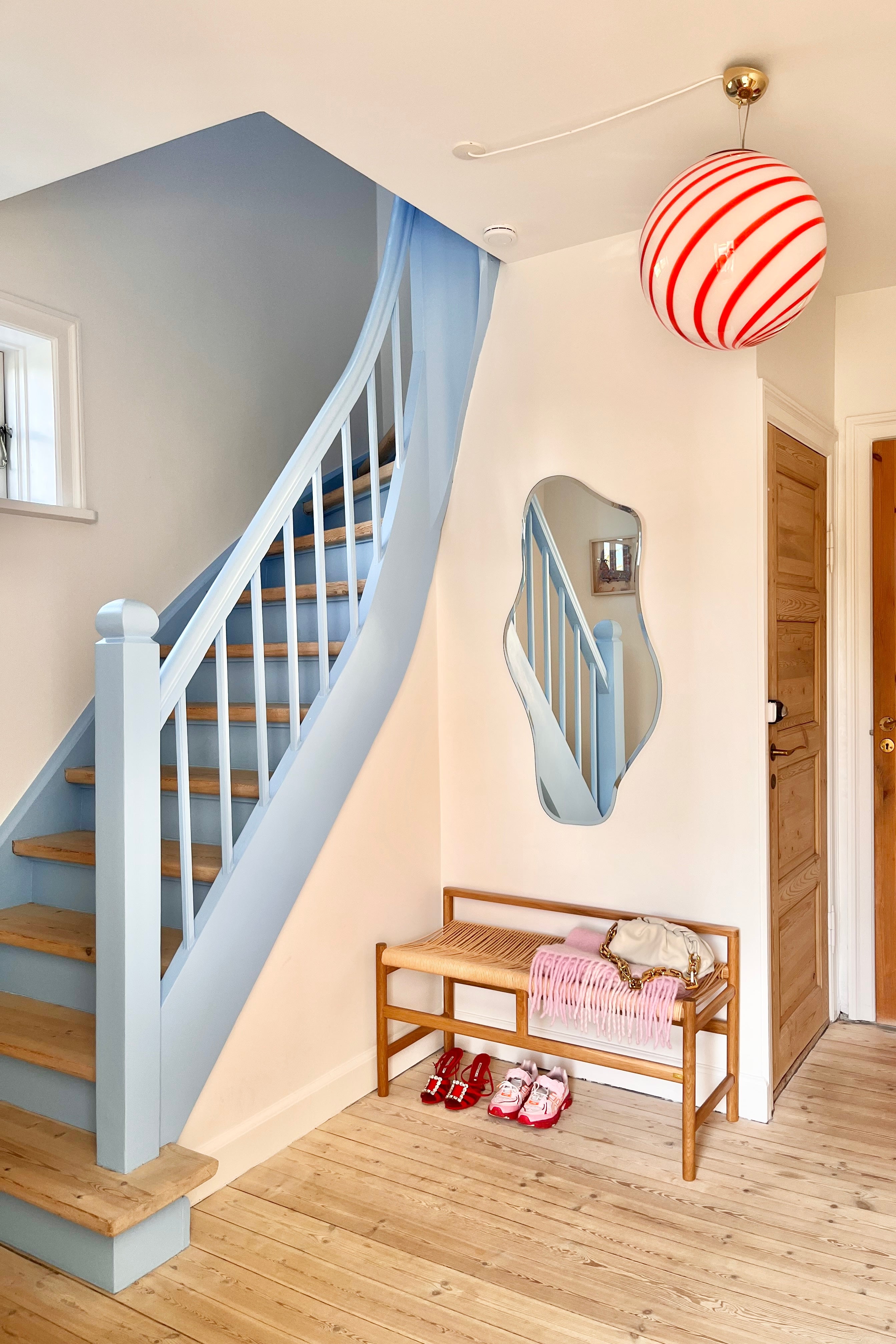 Czerwona i biała lampa wisząca Murano Candy Swirl nad stolikiem w salonie