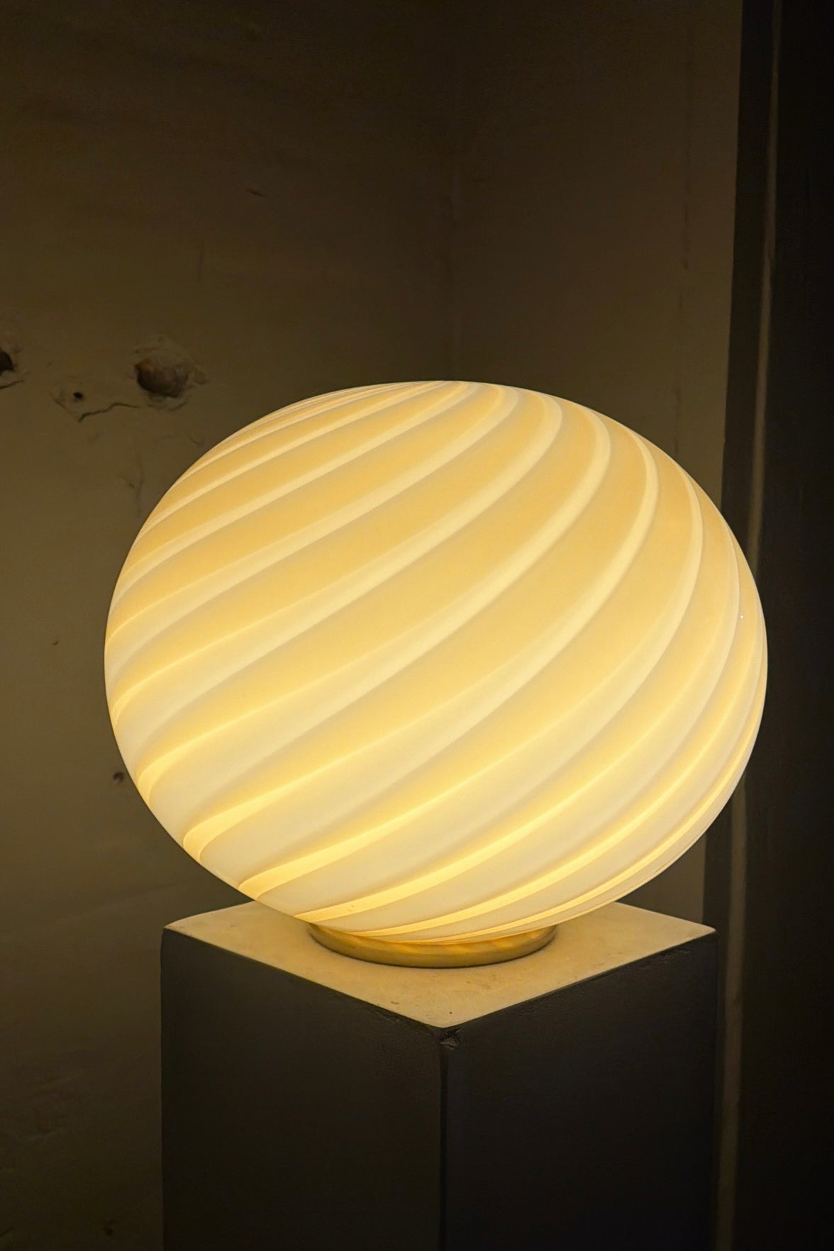 ovale vloerlamp in geel met swirl-patroon, gezien vanaf de zijkant in een lichte ruimte, Murano design