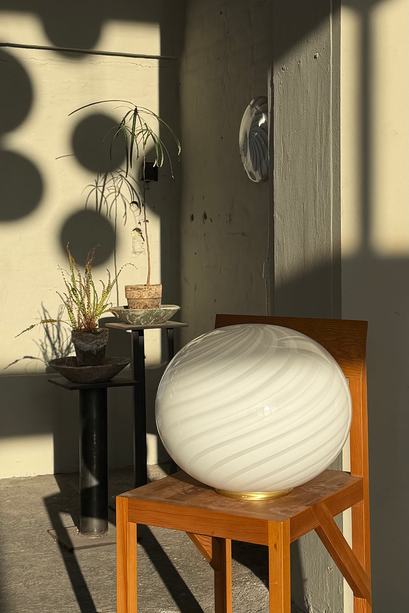 Murano Candy gulvlampe med hvid swirl mønster på en træstol i et lyst rum