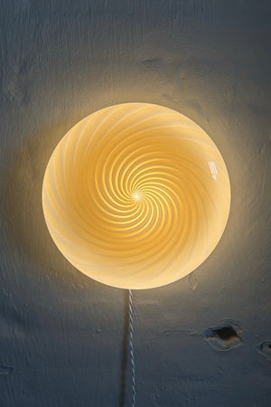 Murano lampe de plafond en or avec motif tourbillonnant, vue latérale sur un mur clair, design élégant et moderne
