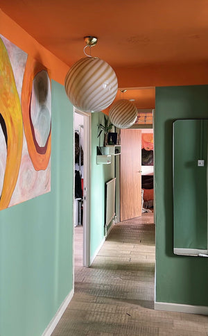 beautiful murano pendant in caramel cream swirl pattern hanging in a colorful hallway, creating a warm atmosphere