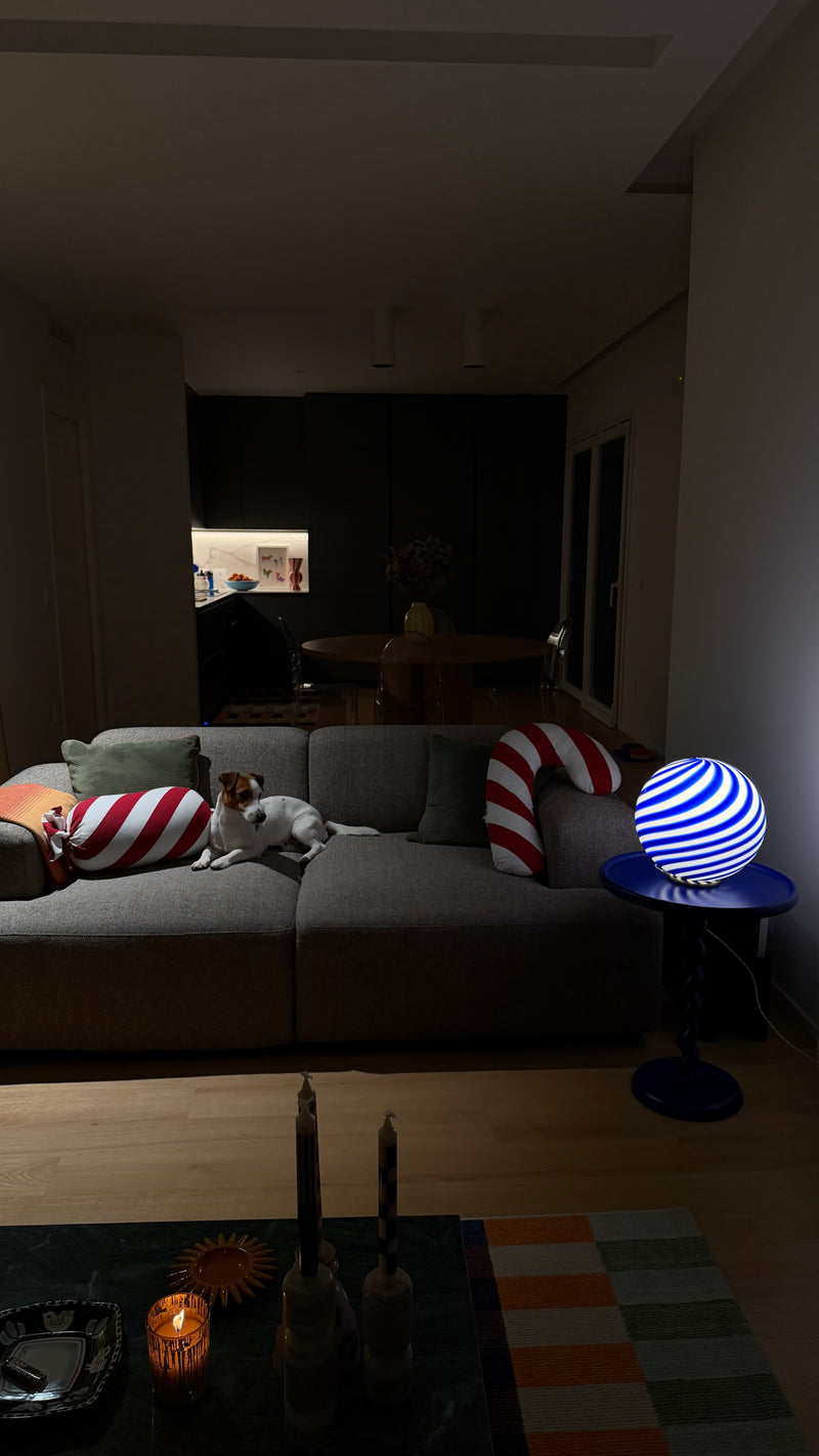 smuk Murano bordlampe i koboltblå/hvid swirl mønster placeret på en blå fod, lyser stuen blødt