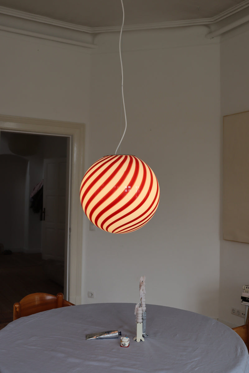 Murano lampa wisząca w bordowo-białym, wirującym wzorze, zawieszona w jadalni na jasnym tle