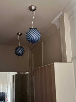 Murano suspension bleu à motif tourbillonnant, suspendue dans une pièce lumineuse aux murs doux