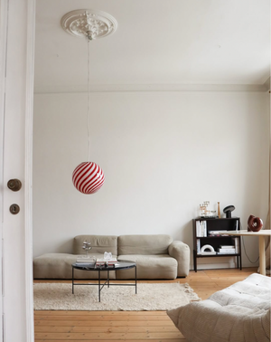 Murano pendant in burgundy red/white swirl pattern hanging in living room with light background