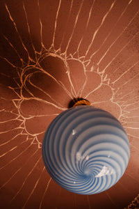Murano candy pendant in blue swirl pattern seen from below, highlighting the elegant design and the unique light pattern on the ceiling