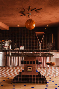 large Murano pendant in orange amber with swirl pattern hanging over a modern kitchen bar