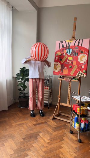 Murano floor lamp with red/white swirl pattern stands in a bright room beside artwork