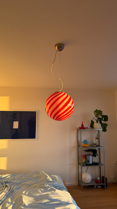 Murano pendant with red/white swirl pattern, hanging in a bright room that highlights the 30 cm size